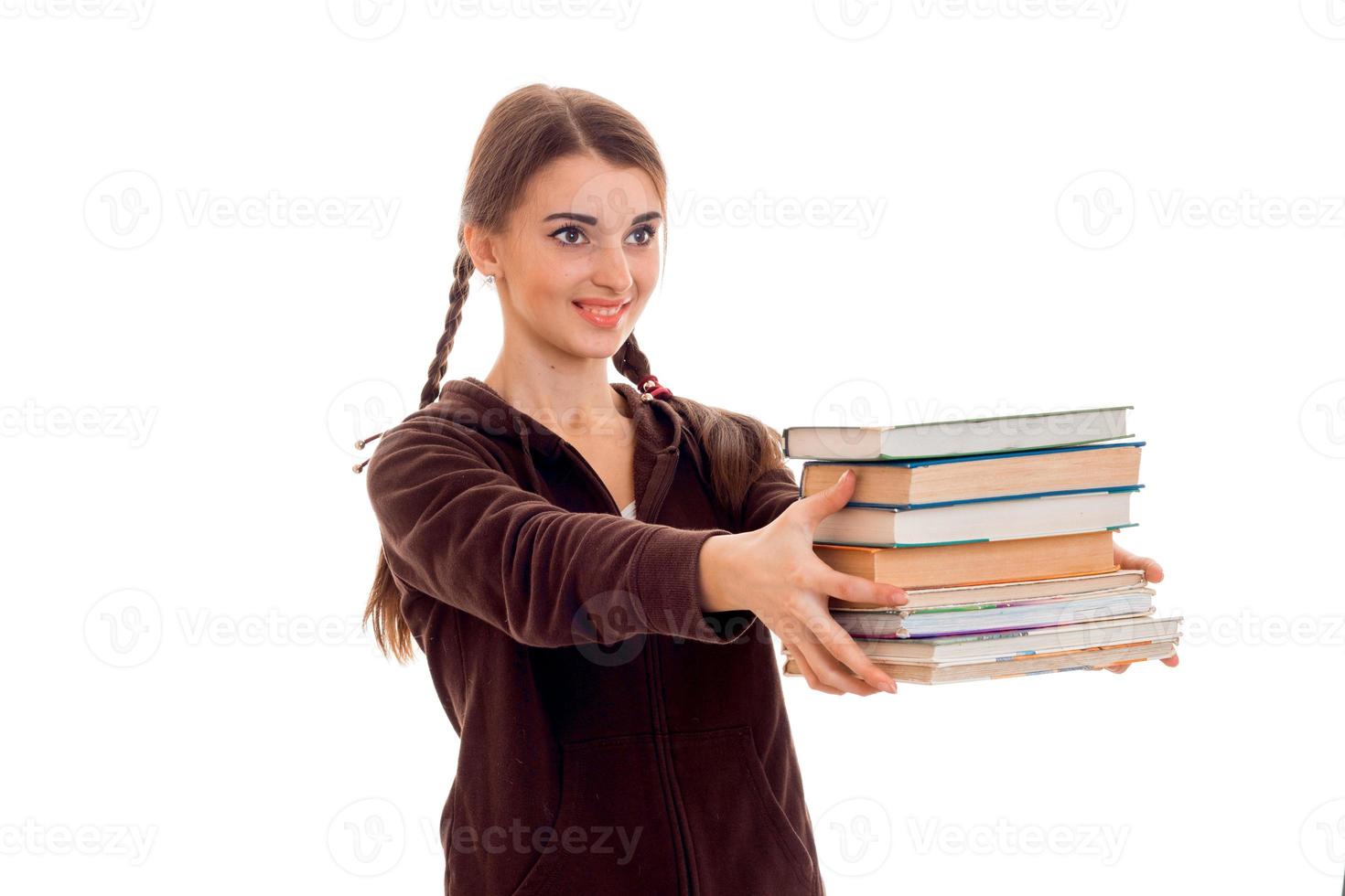 cheerful young student girl with books in brown sport clothes smiling isolated on white background. student years concept. study concept. photo