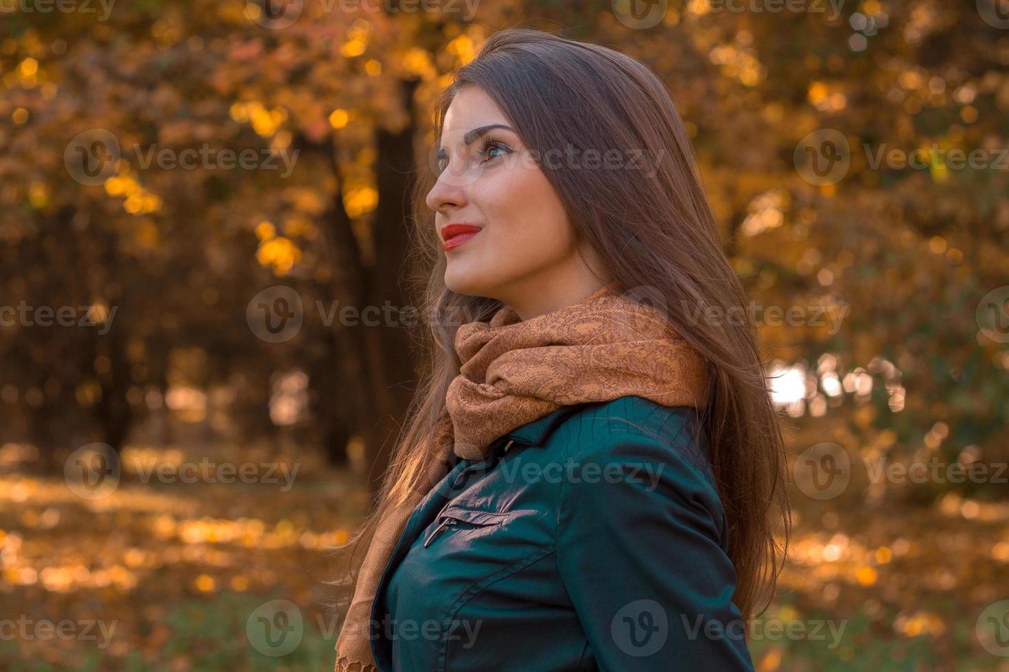 young girl stands on the street turning sideways and looks into the distance photo