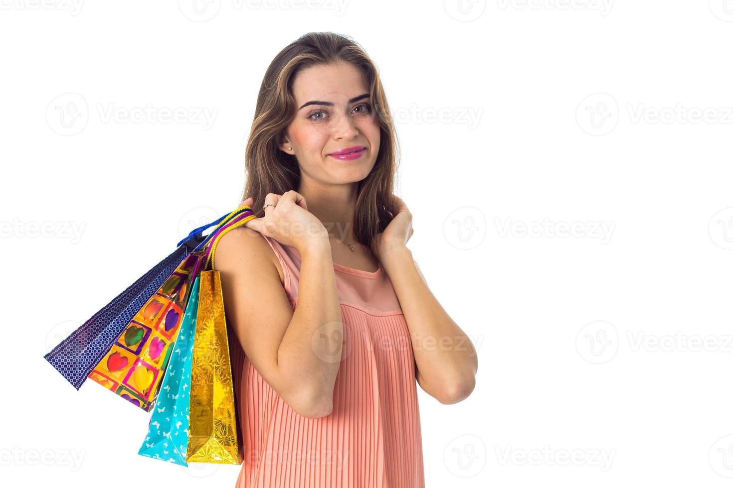 la niña mantiene sobre su hombro paquetes multicolores con regalos aislados en un fondo blanco foto