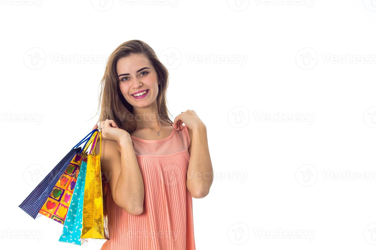 young girl keeps on his shoulder a lot of beautiful packages and smiling isolated  white background photo