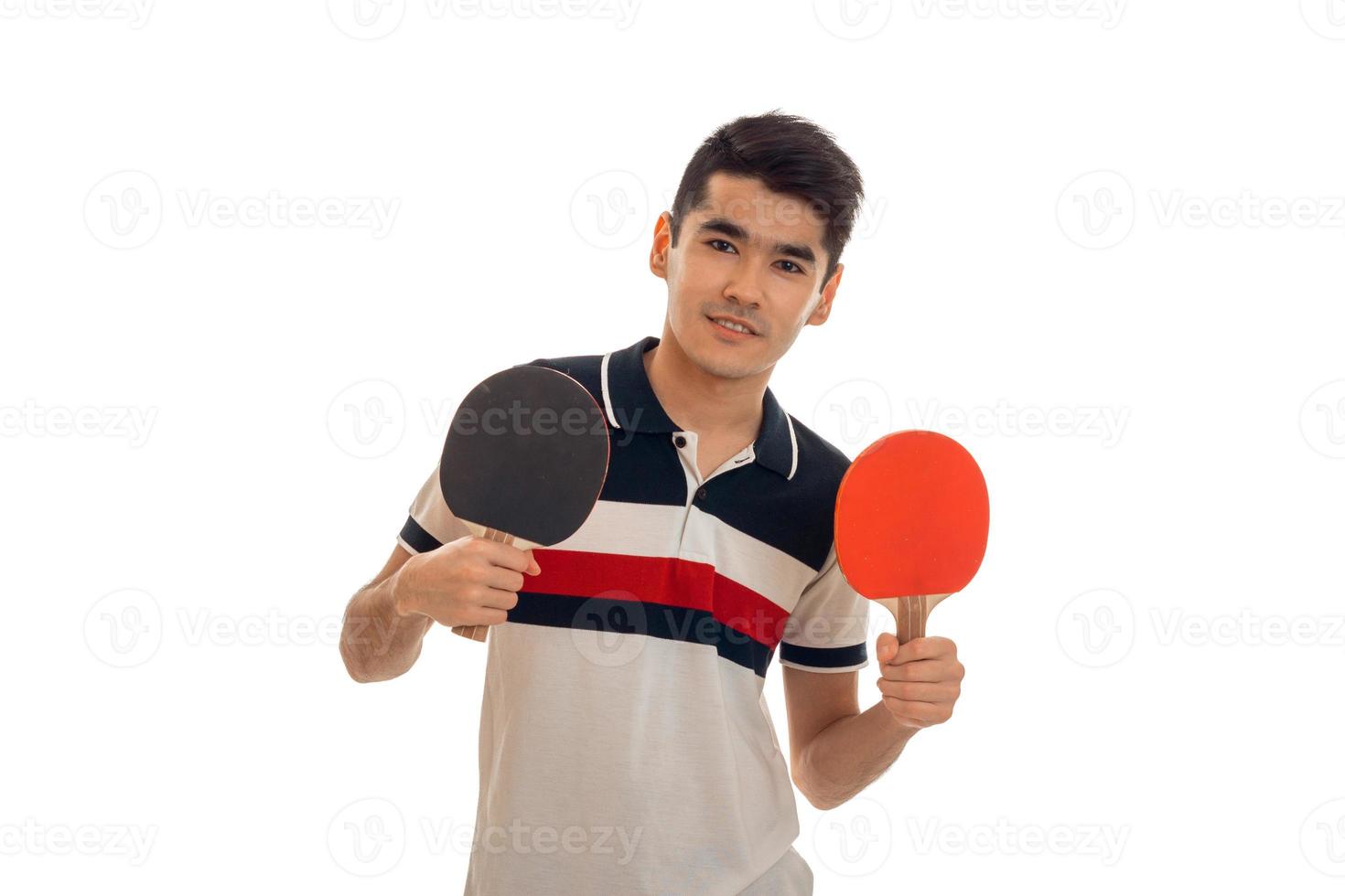 young guy stands up straight and holding rackets for table tennis is isolated on a white background photo