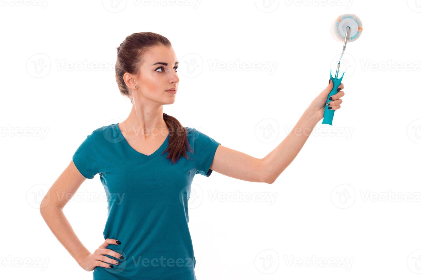 young pretty brunette woman builder in uniform with paint roller in hands make reovations isolated on white background photo