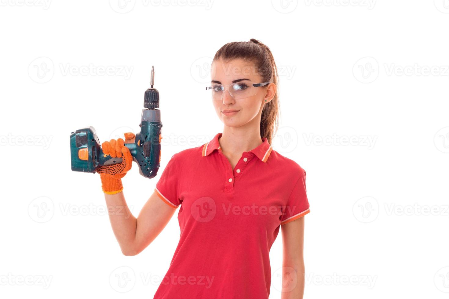 young attractive brunette woman builder in uniform with glasses and drill in her hands make reovations isolated on white background photo