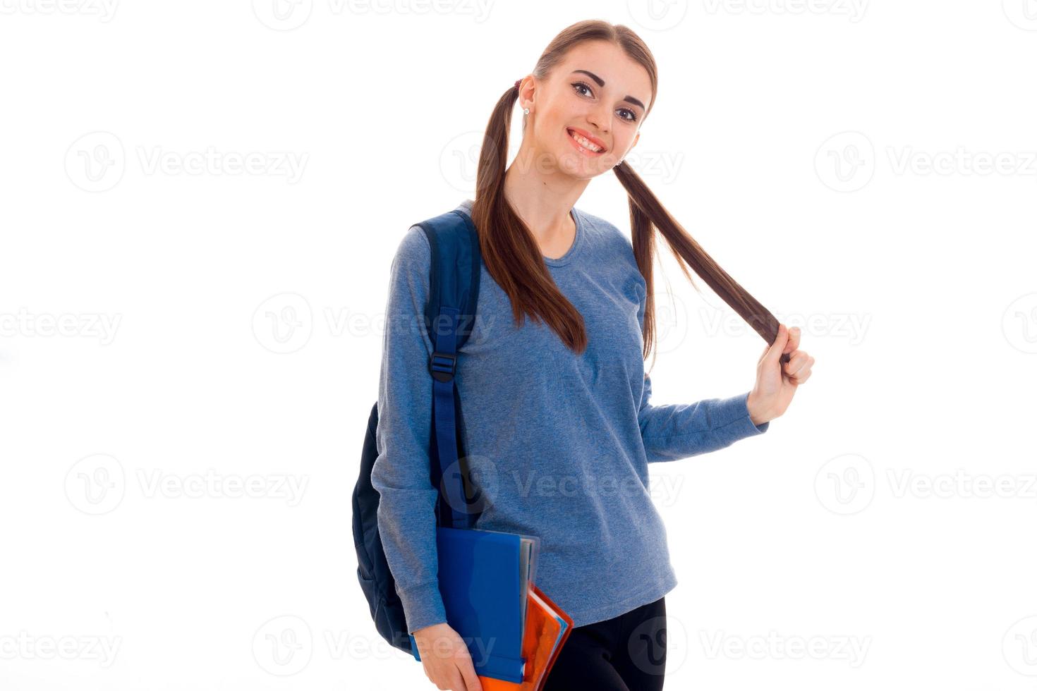 una adolescente alegre mira hacia otro lado y mantiene la mano del cabello foto