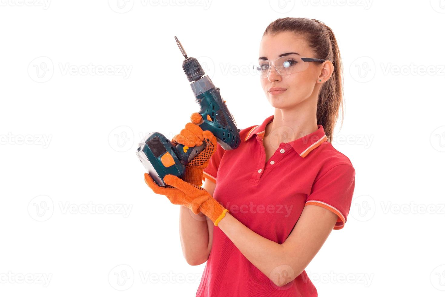 beautiful young girl in a red t-shirt and goggles holds drill photo