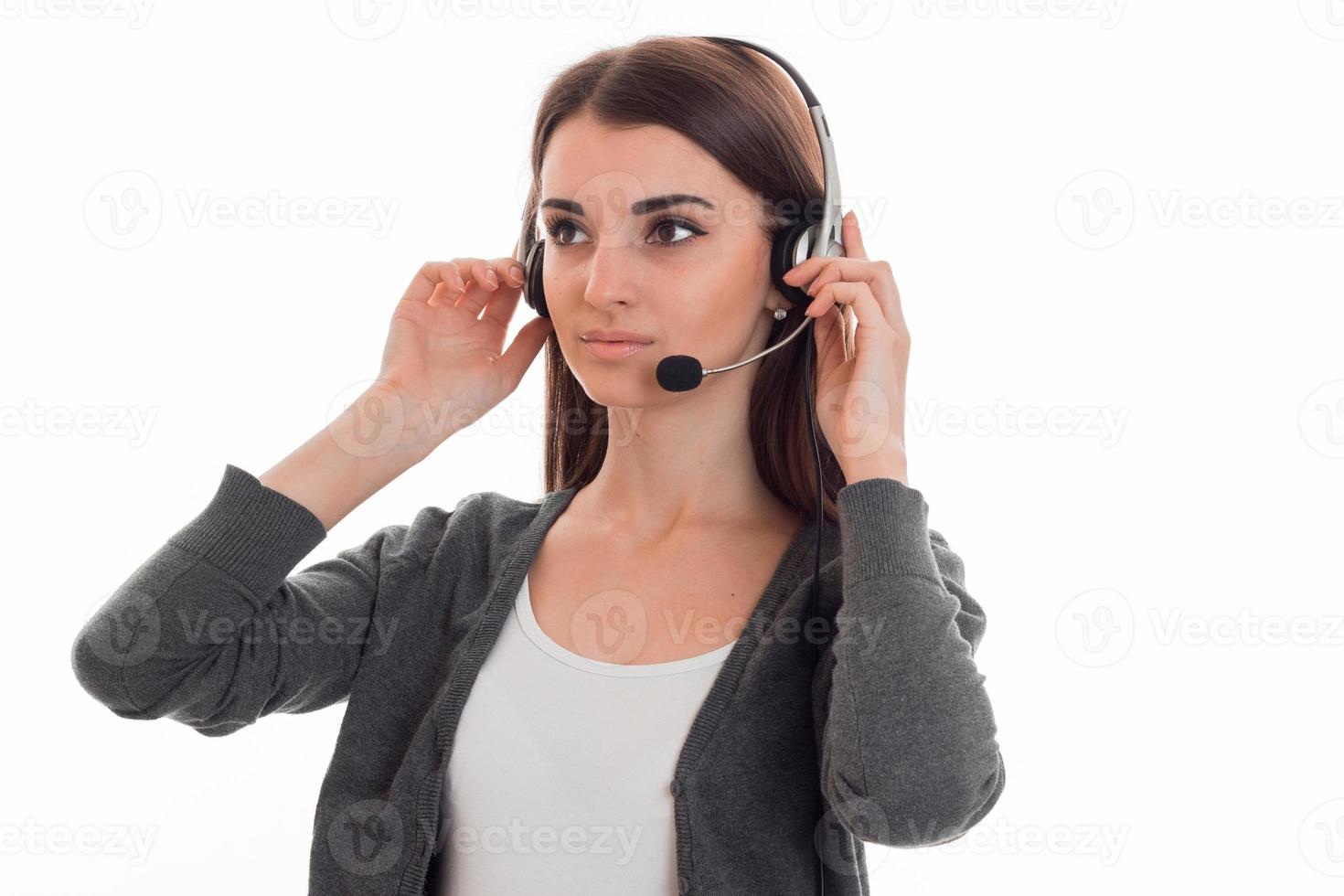 young serious girl in headphones keeps their hands and looks towards photo