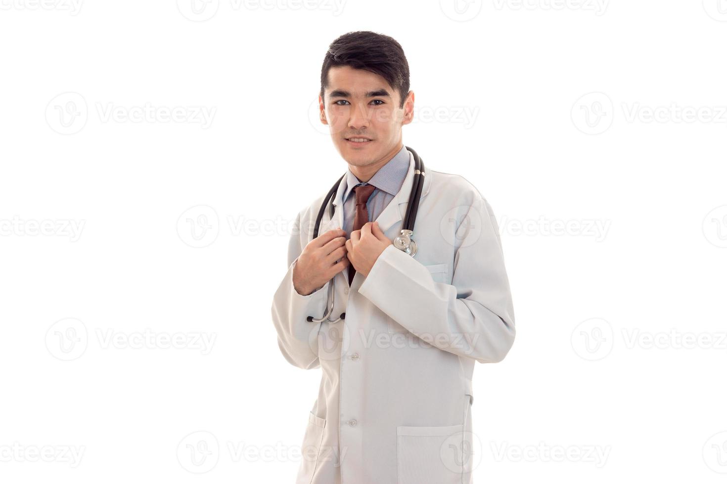 Morena joven médico en uniforme azul con estetoscopio en el cuello aislado sobre fondo blanco. foto