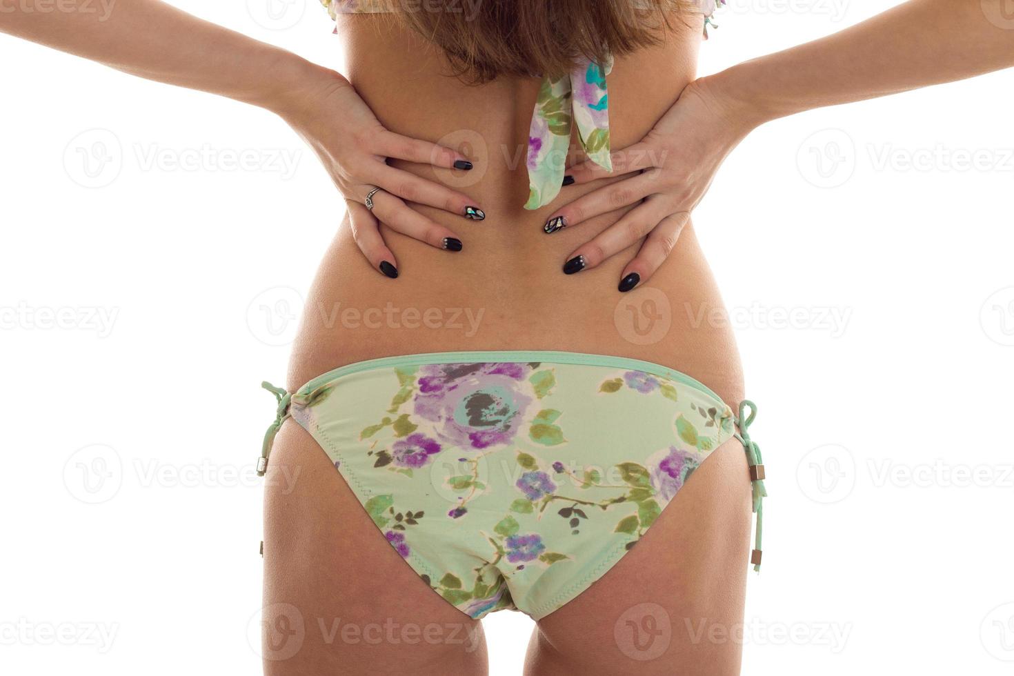 girl in a bathing suit is worth turning your back to the camera with beautiful buttocks and keeps his hands on the sides of a close-up photo