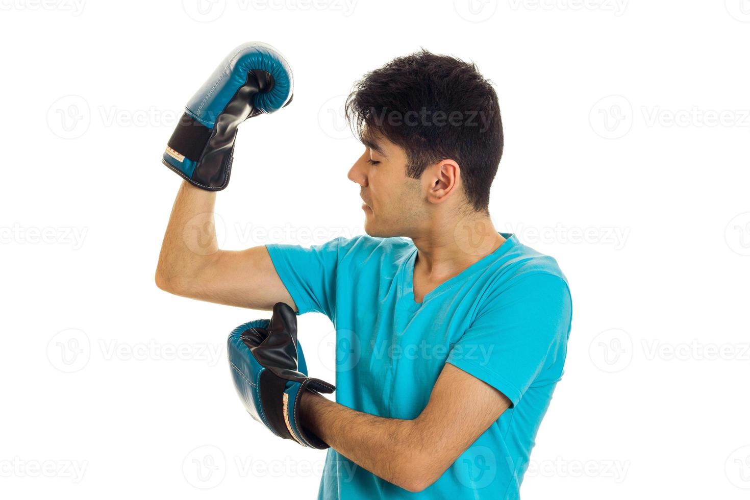 young guy stands sideways in boxing gloves photo