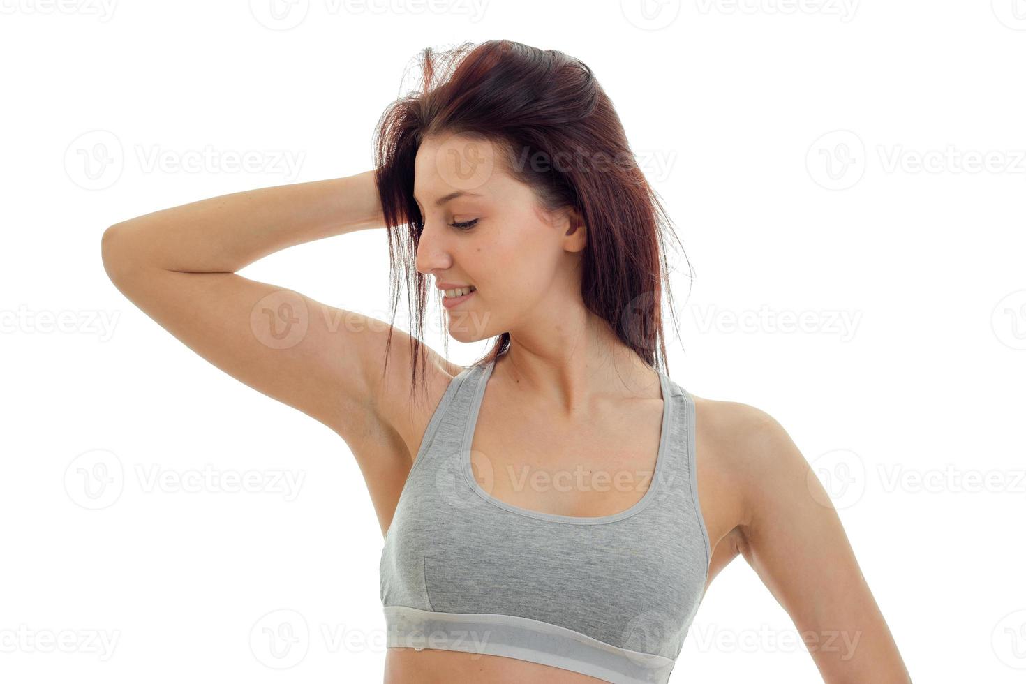 beautiful young girl in grey top looks away and keeps a hand near hair photo