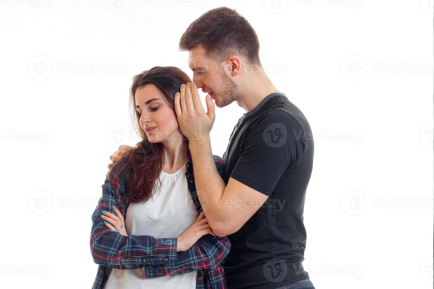young guy says something to the girl in her ear and she is smiling photo