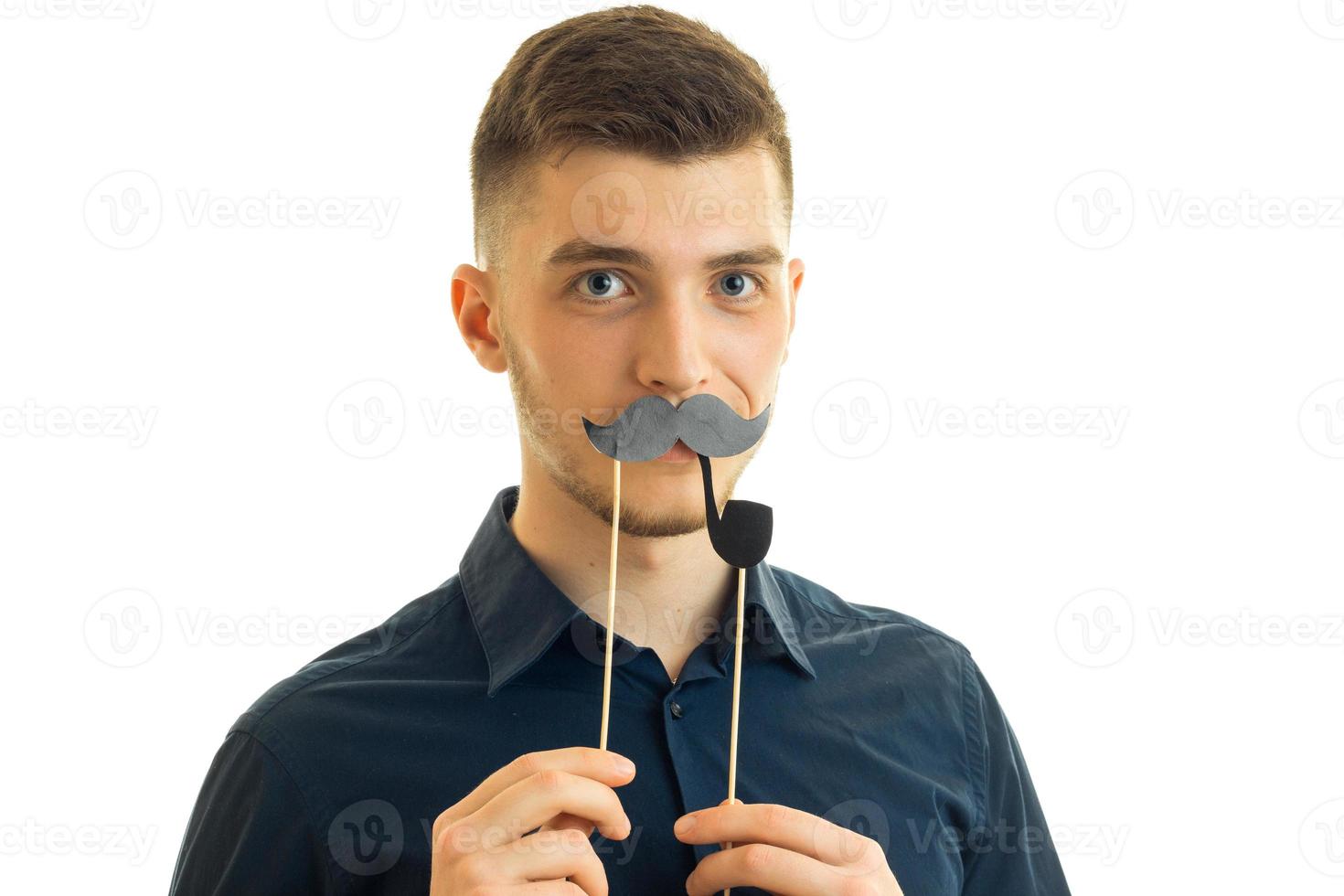 young charming guy keeps near the face, paper mustache photo