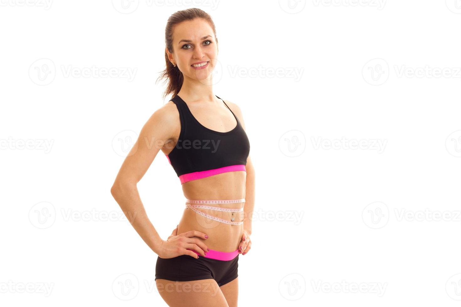 Slim beautiful girl in sports top smiling and posing for the camera photo