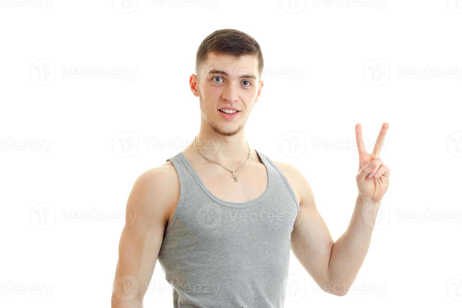 guy looks into the camera and hand gesture with raised up two fingers photo