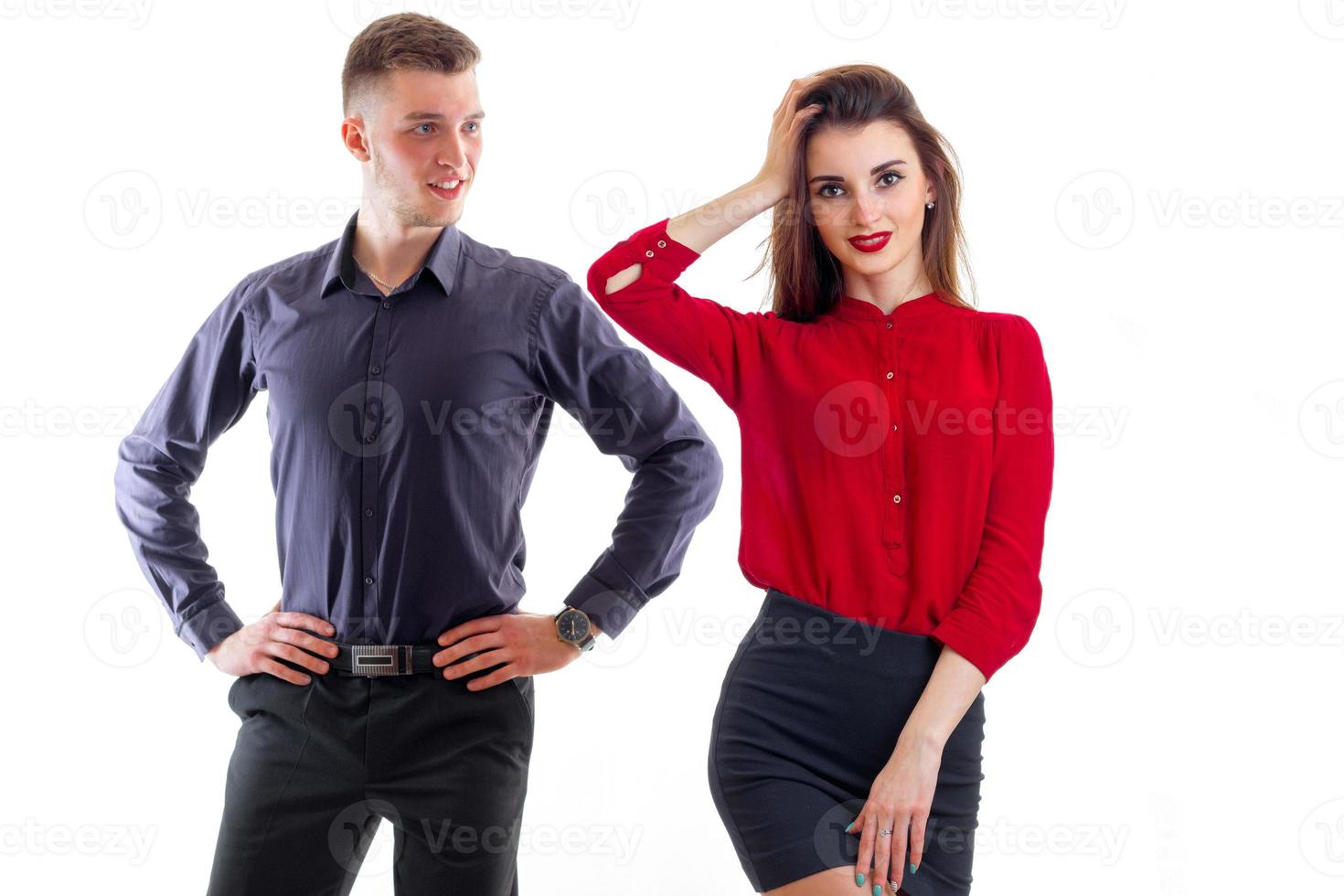 handsome young man put hands on hips and standing next to a beautiful girl that keeps your hand near hair photo