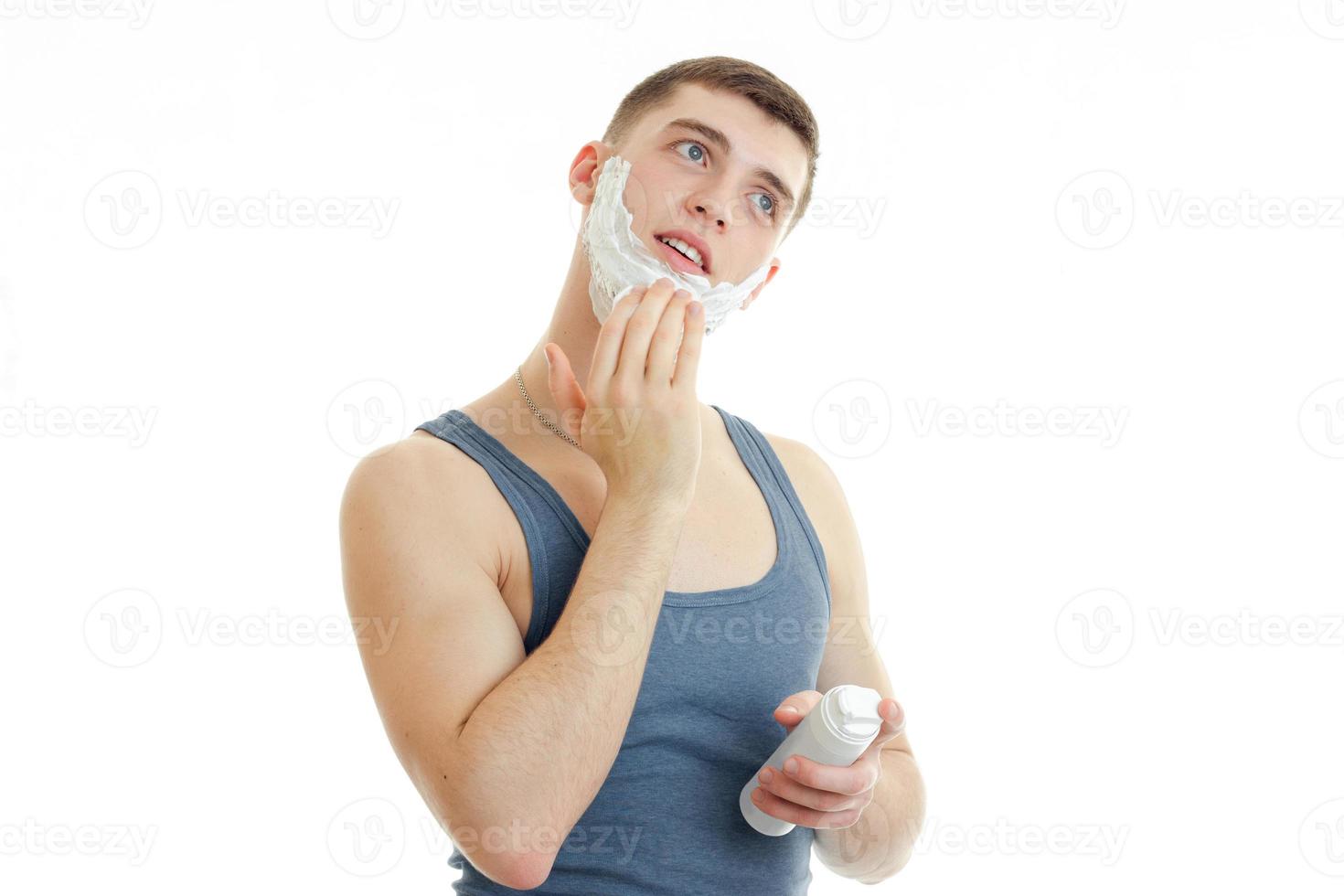 handsome young guy in a t-shirt worth bending head and putting foam face photo