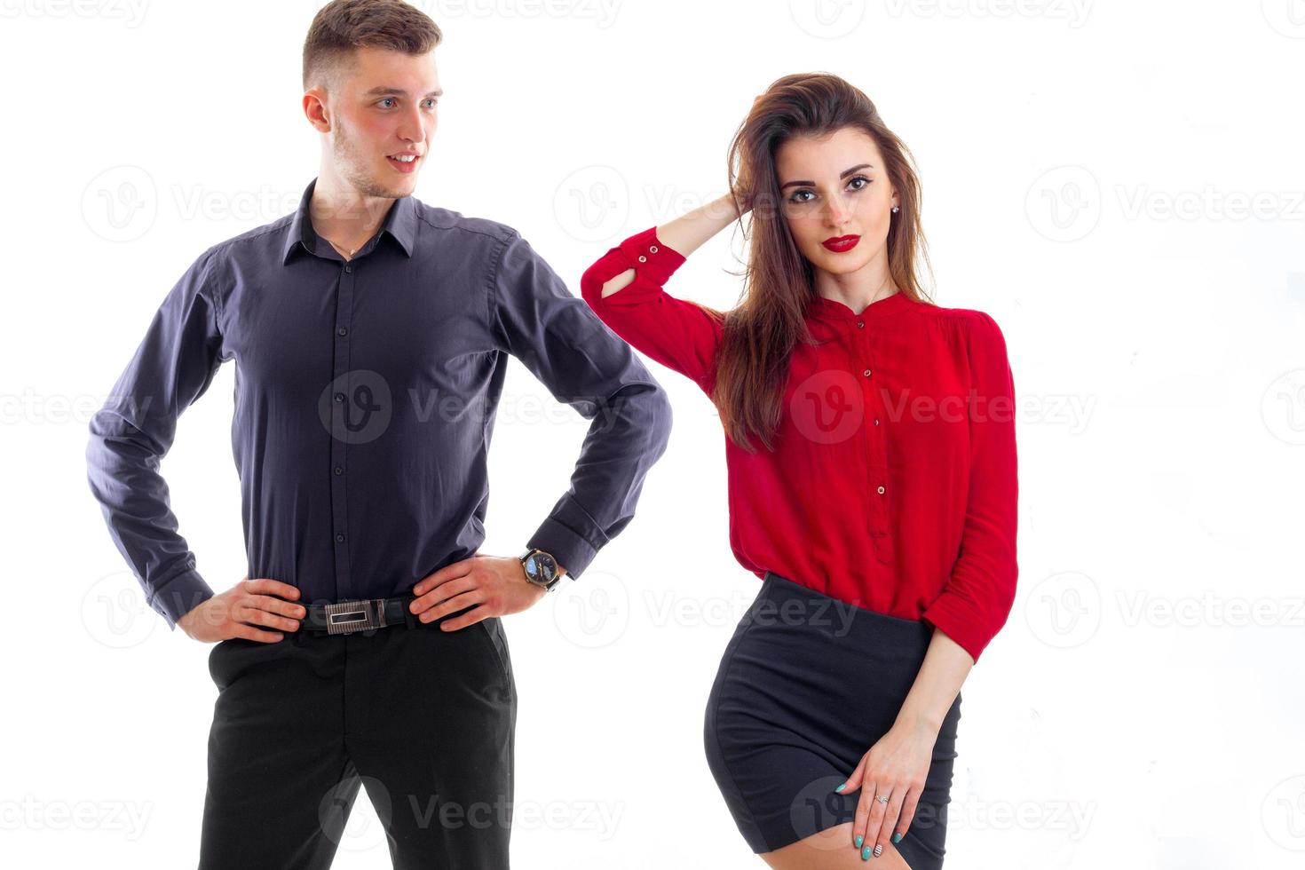 romantic young girl in a red blouse and with lipstick on lips stands near high guy who looks at her photo