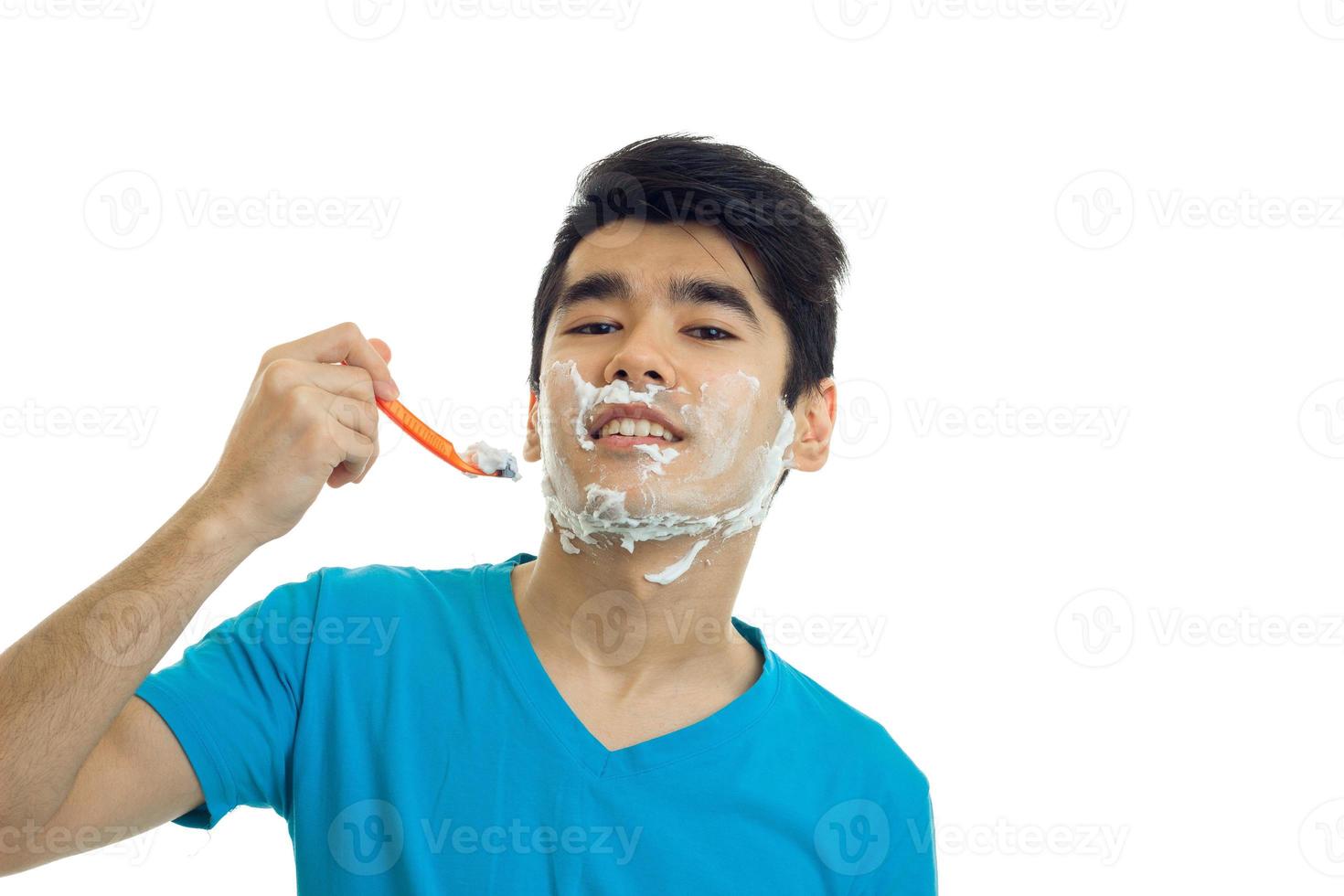 joyful young guy with black hair tilted his head back and looks right shaves photo