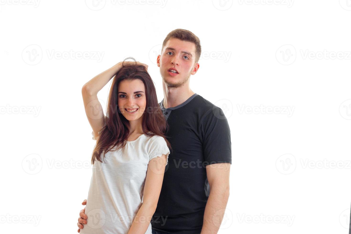 fun pretty girl holding hand hair and stands next to severe charming guy photo