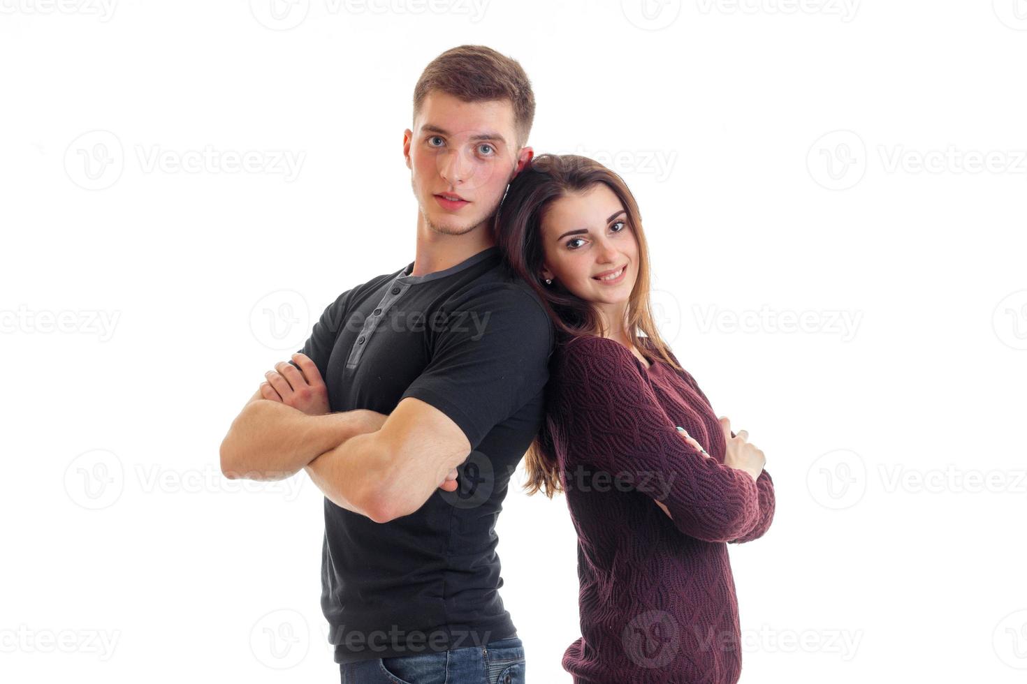 handsome guy and a young charming girl smiling and standing back to each other hands photo