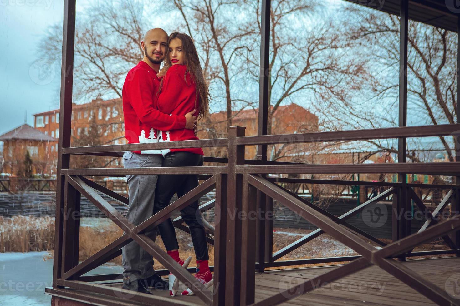 Charming young couple in love hugs on a balcony winter time photo