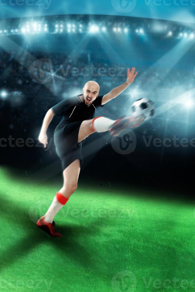 hombre jugando fútbol y disparando una pelota en el juego foto