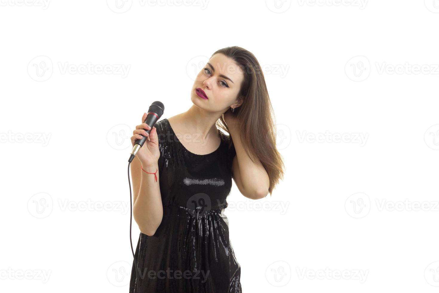 Woman in bright black dress with microphone in hands photo