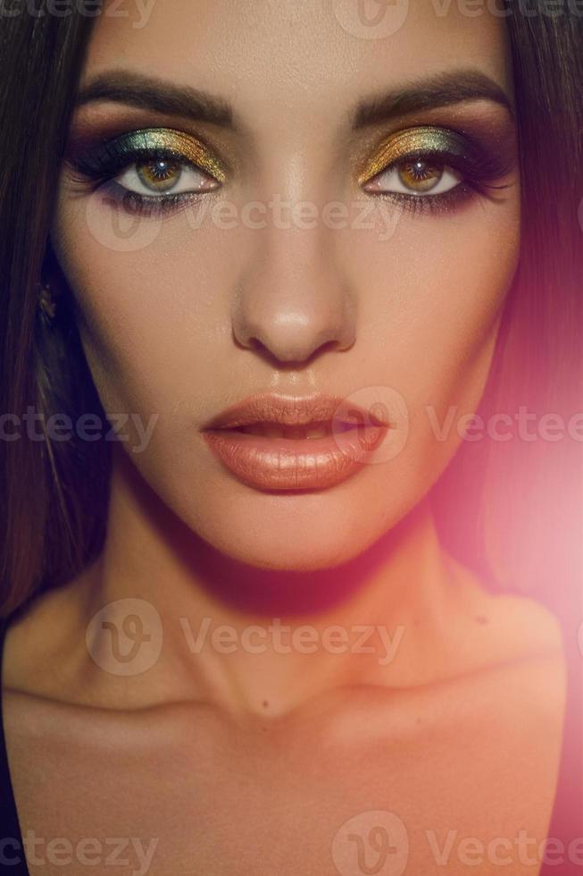Close up of beauty woman with multicolor make up looking at the camera photo