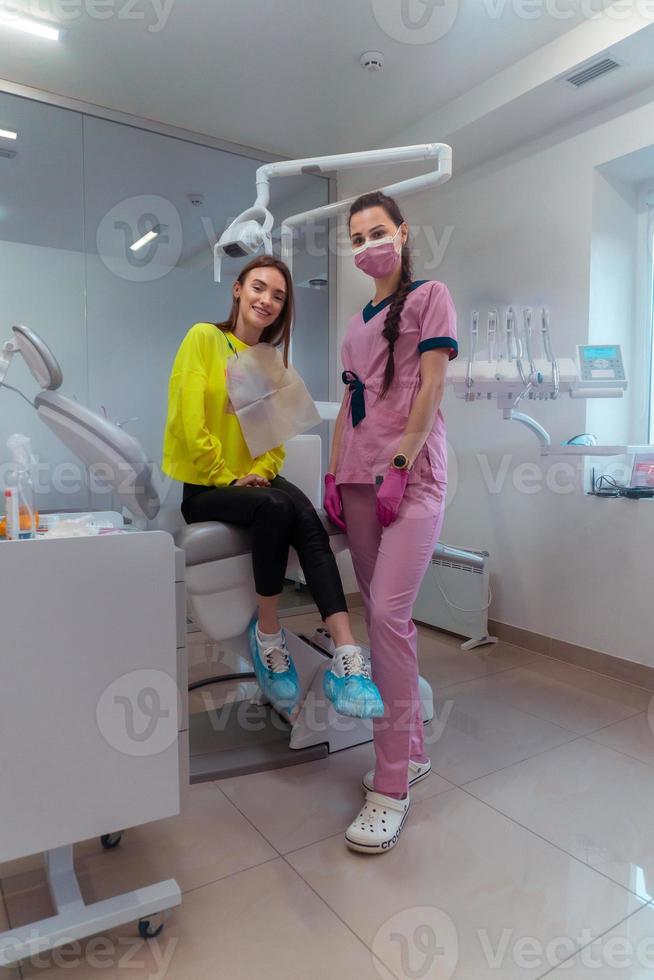 Happy patient girl and dentist in clinic photo