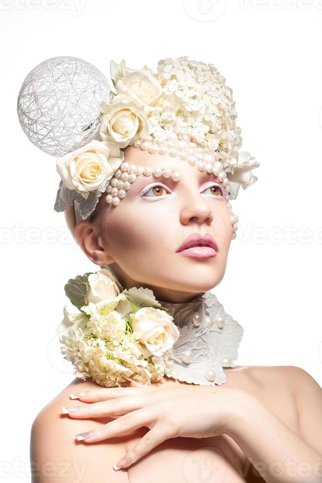 Pretty young girl with tender makeup and flowers on white background. photo