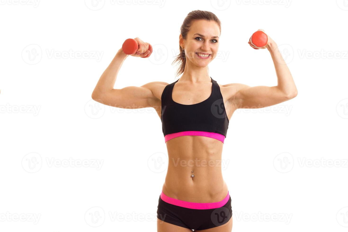 fun energetic athlete raised the dumbbells in your hands looks into the camera and laughs photo
