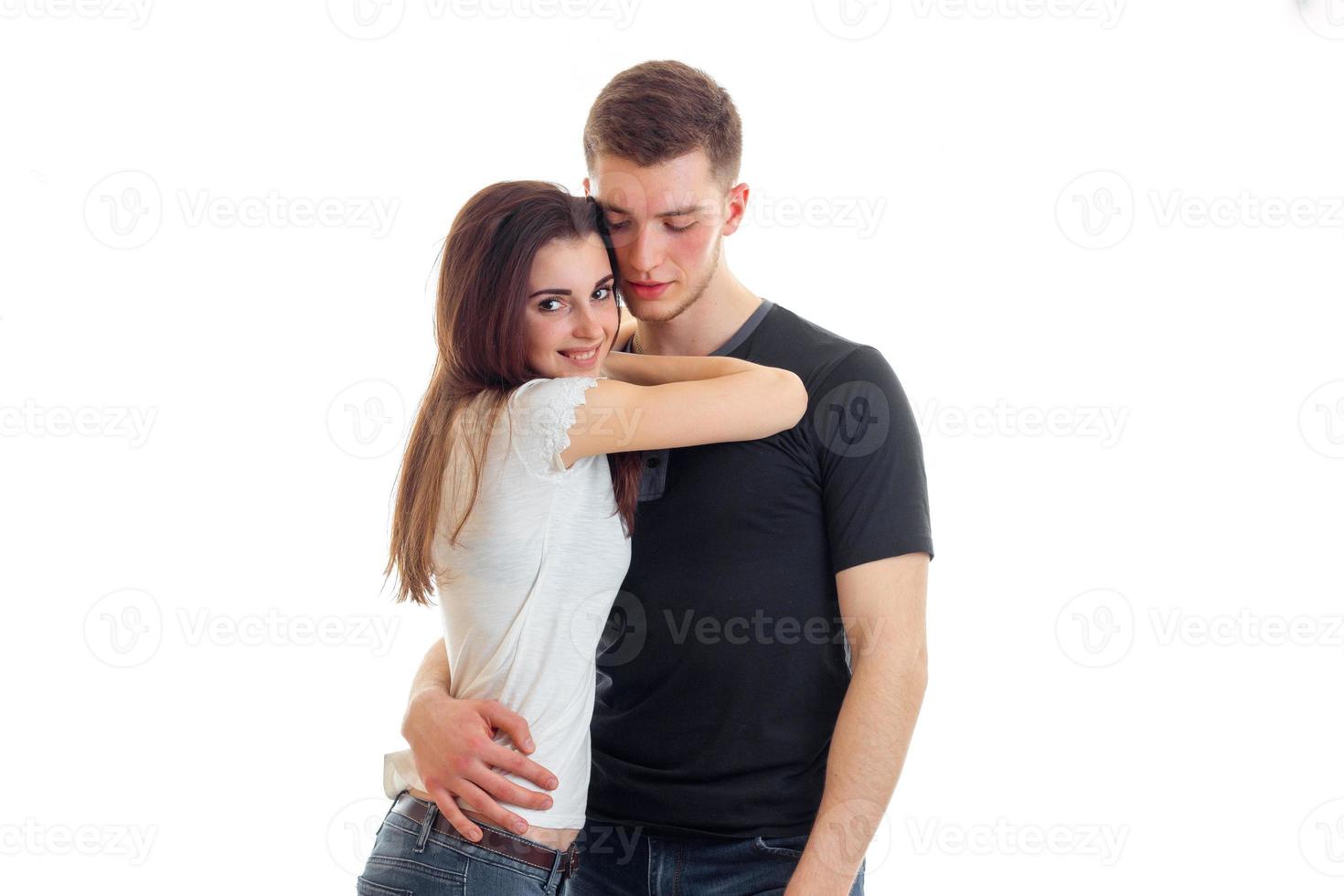 cute young brunette snuggled to the guy and he's hugging isolated on a white background photo