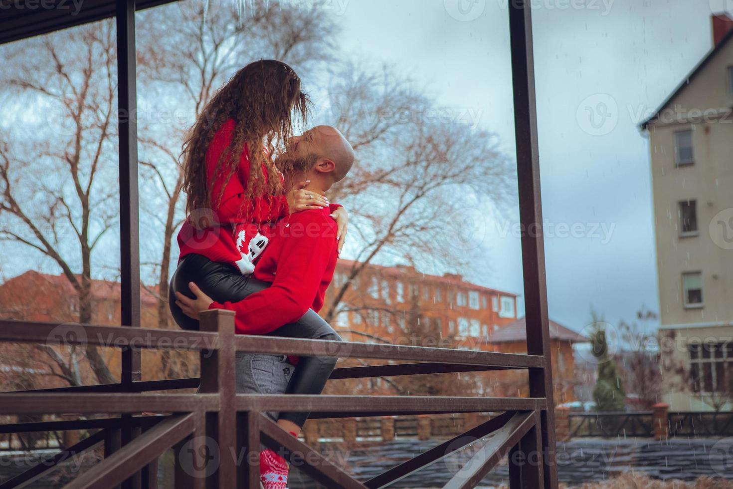 horizontal photo of passionate couple hugs on a balcony winter time. Christmas Mood