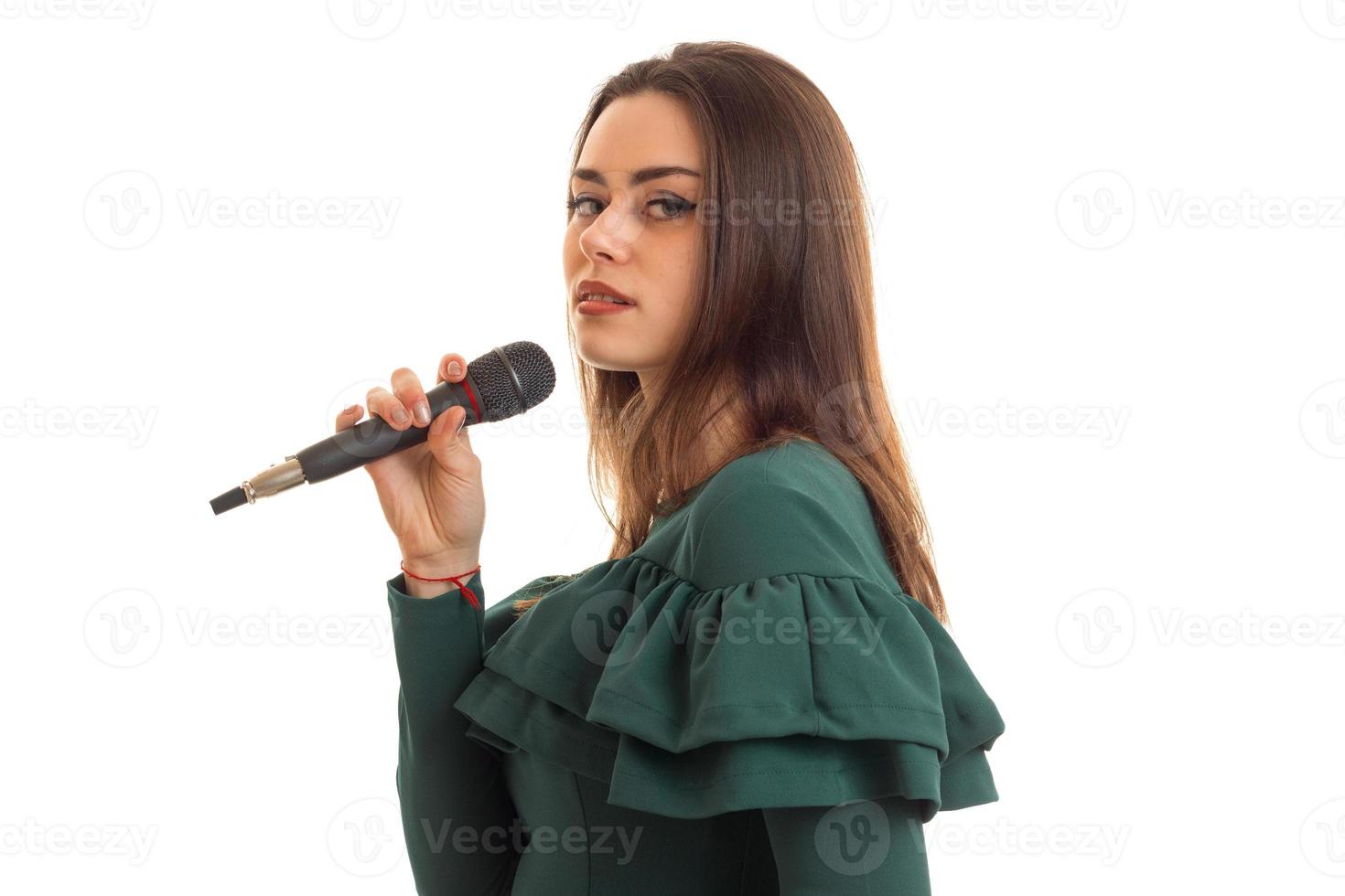 chica joven seria canta un karaoke en el micrófono foto