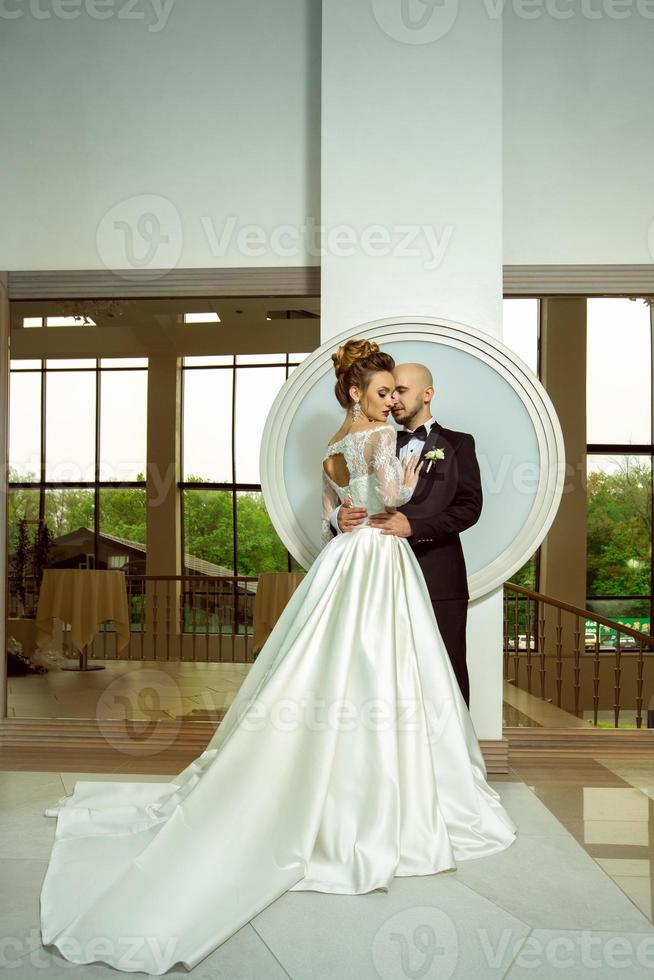 young beautiful married couple in wedding suits hugging photo