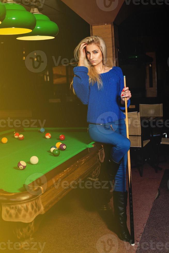 Beddable younge beauty woman posin at pool table photo