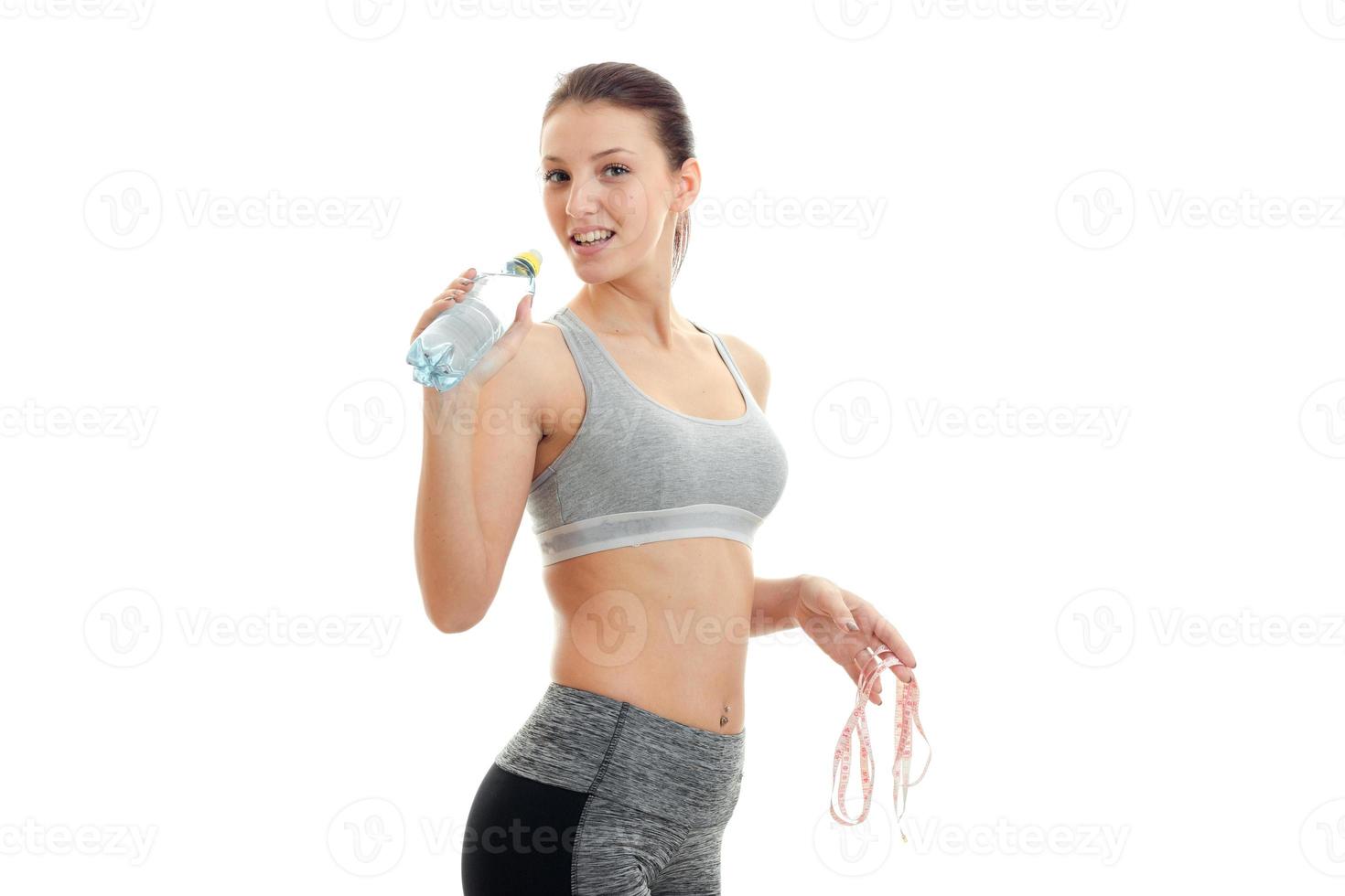 young sports woman in tight uniform drinks water photo