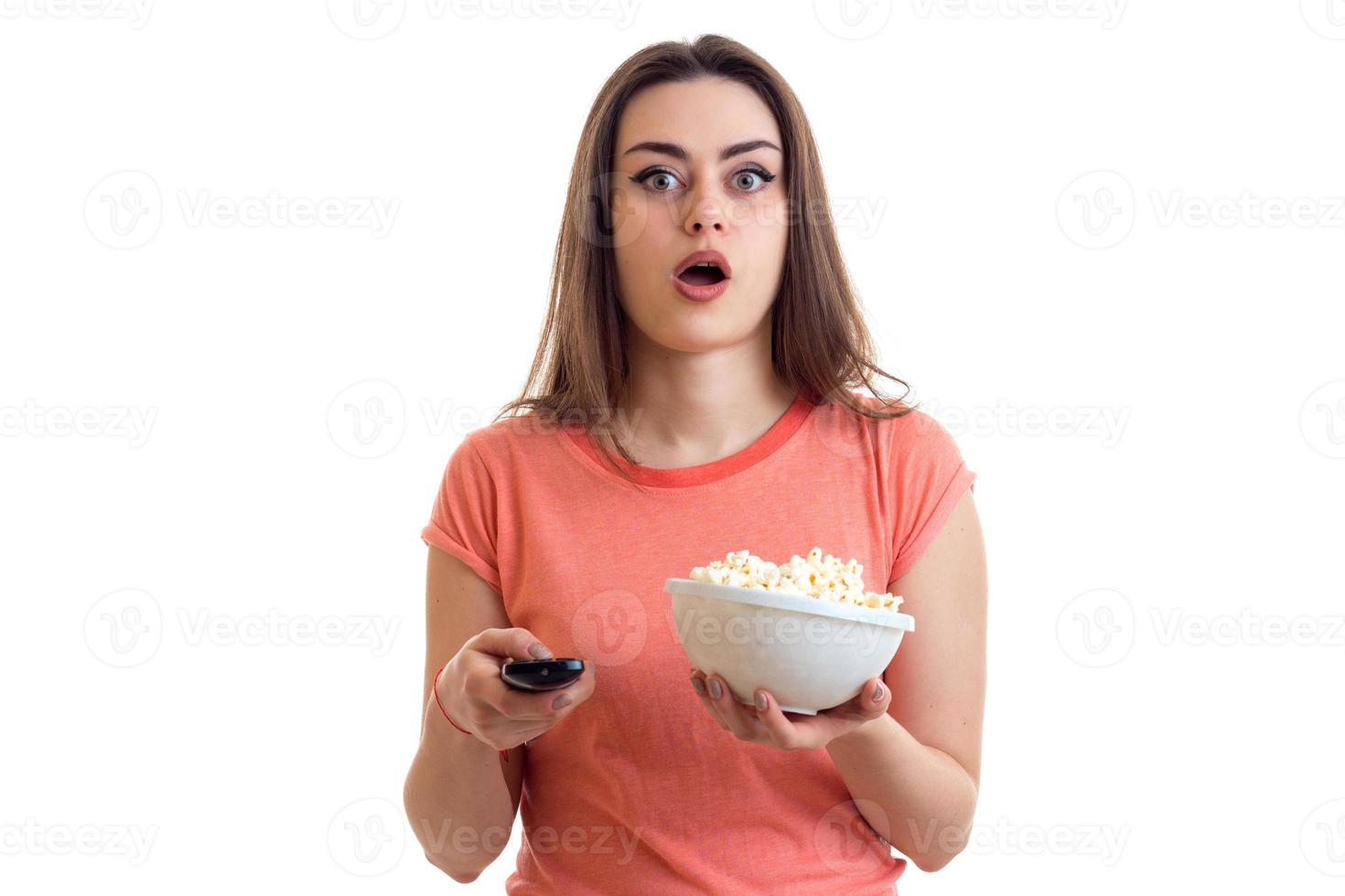 surprised young girl watching a tv with pop-corn photo