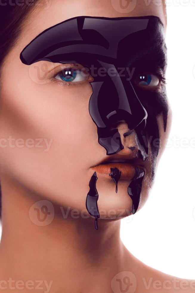 Charming adult girl with black paint on face looking at camera photo