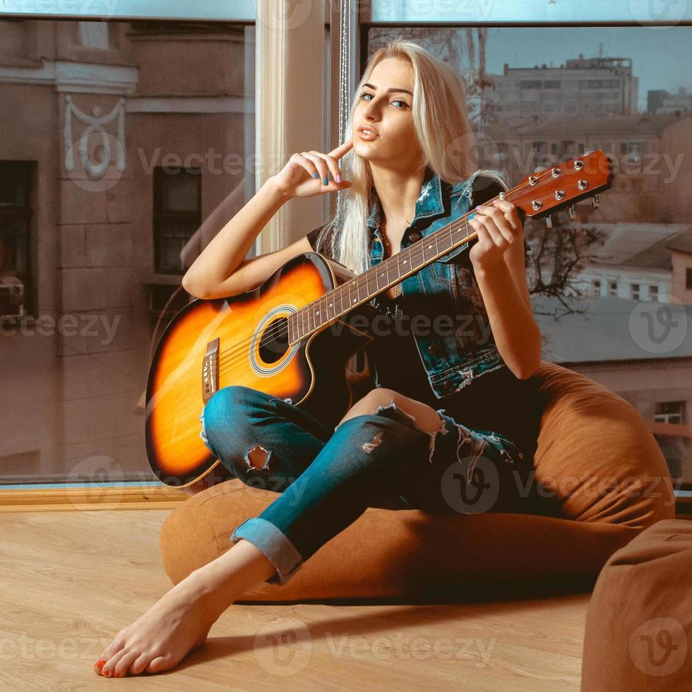 imagen cuadrada chica joven moderna con una guitarra en las manos foto