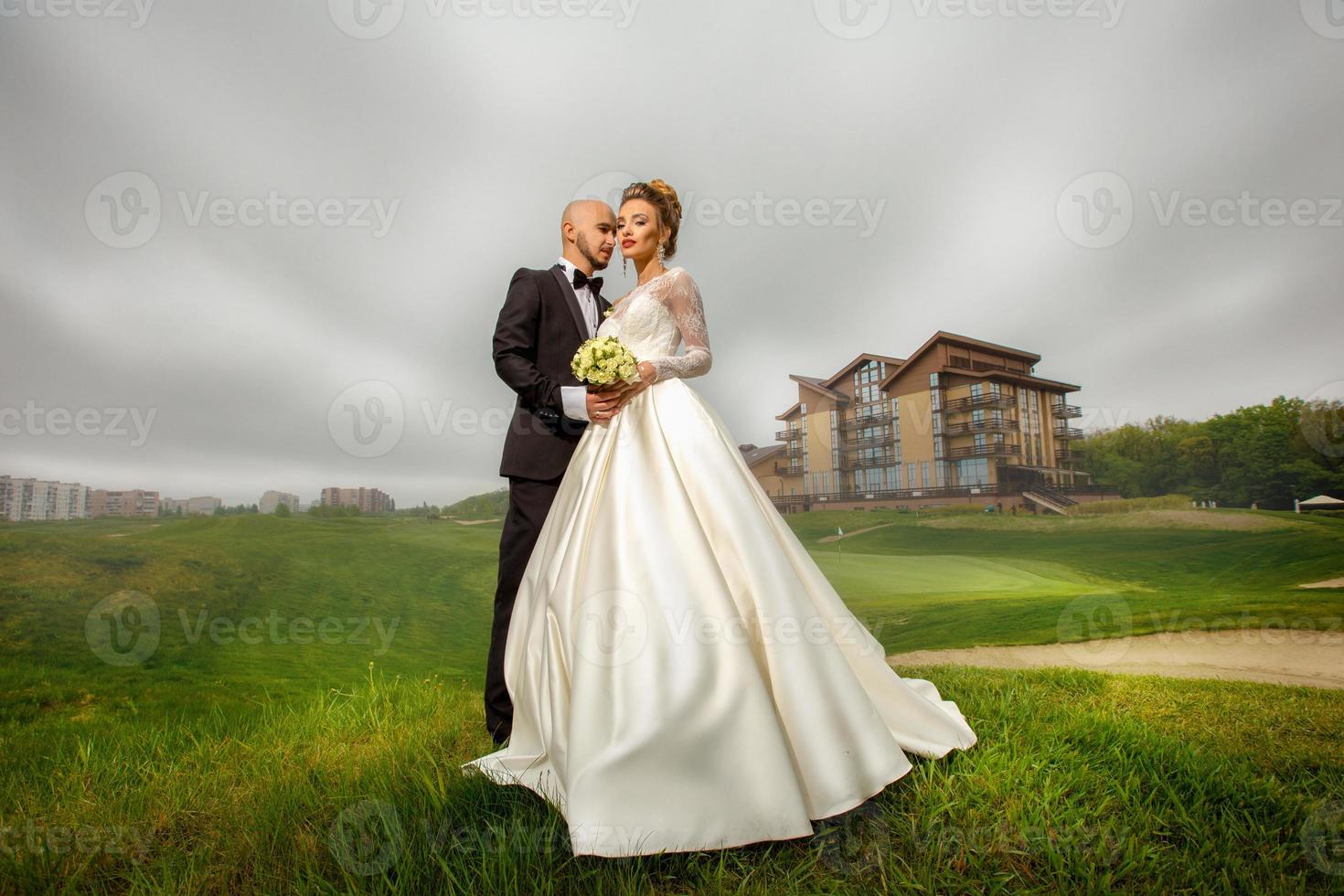 Young fashionable married couple hugs outdoors photo