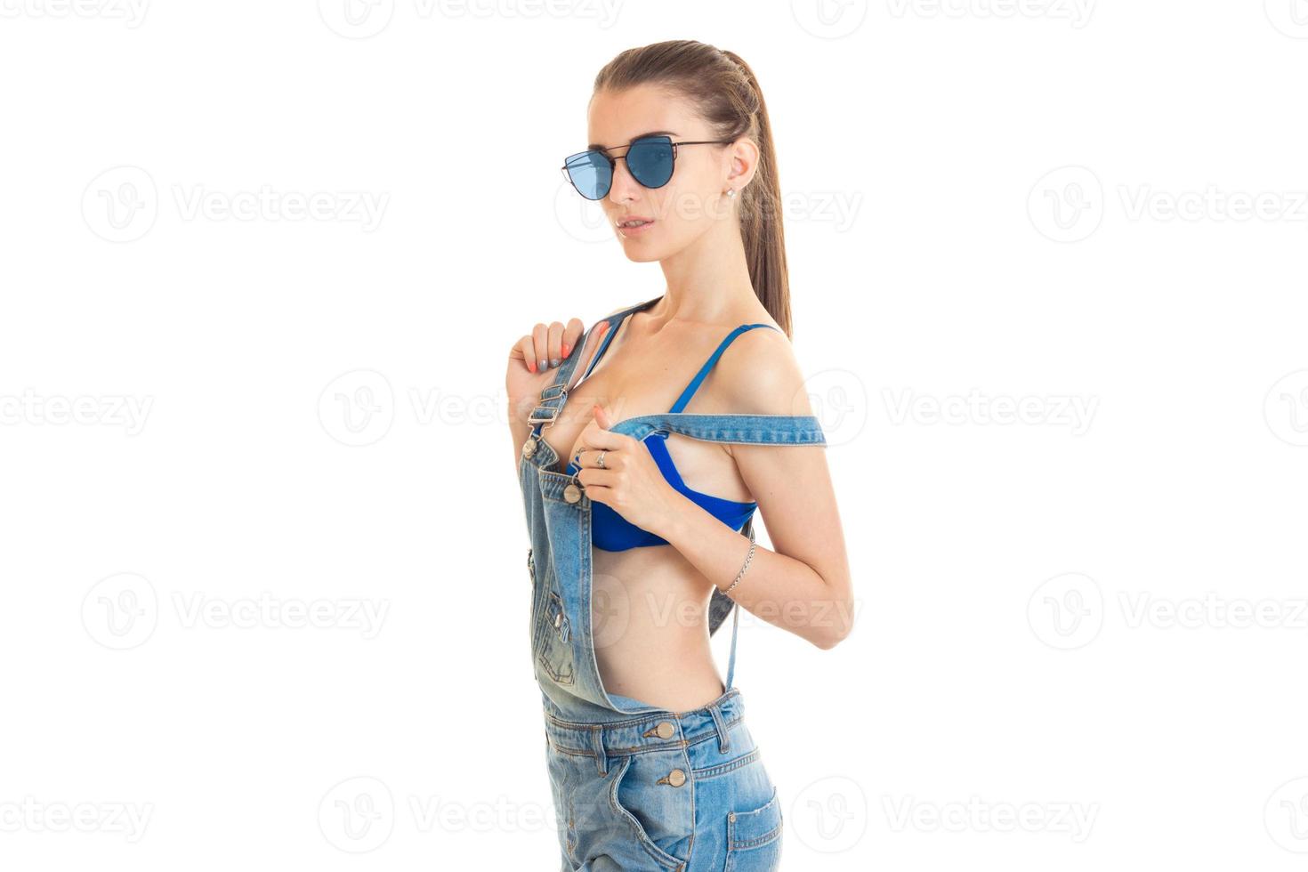 Fashionable lady with big natural boobs wears a jeans clothes and looks at the camera photo