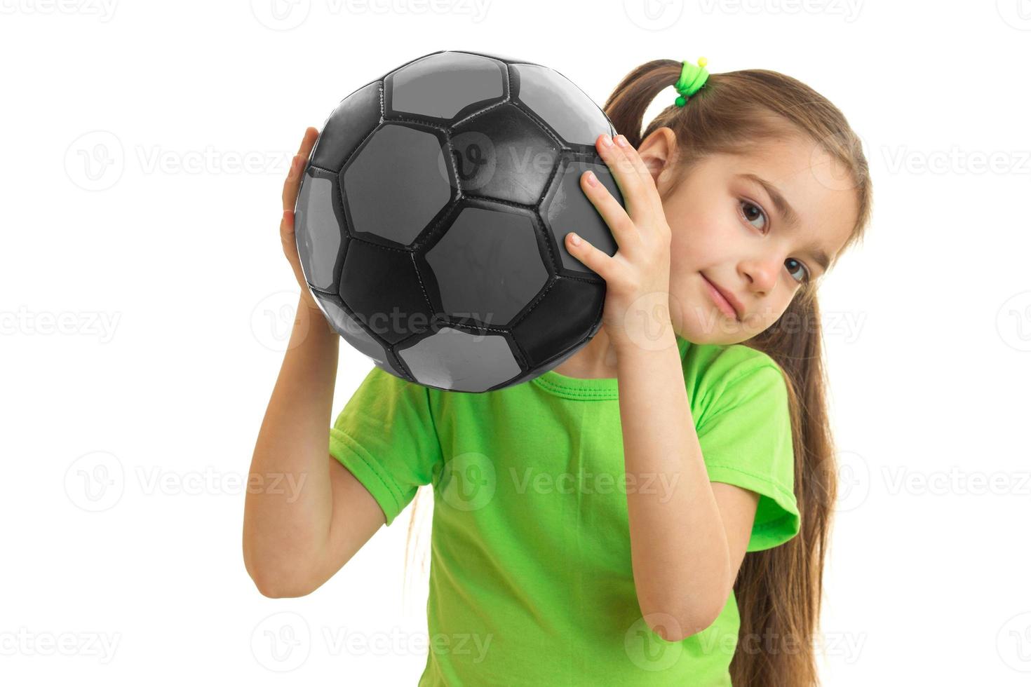 little girl playing football in soccer ball photo