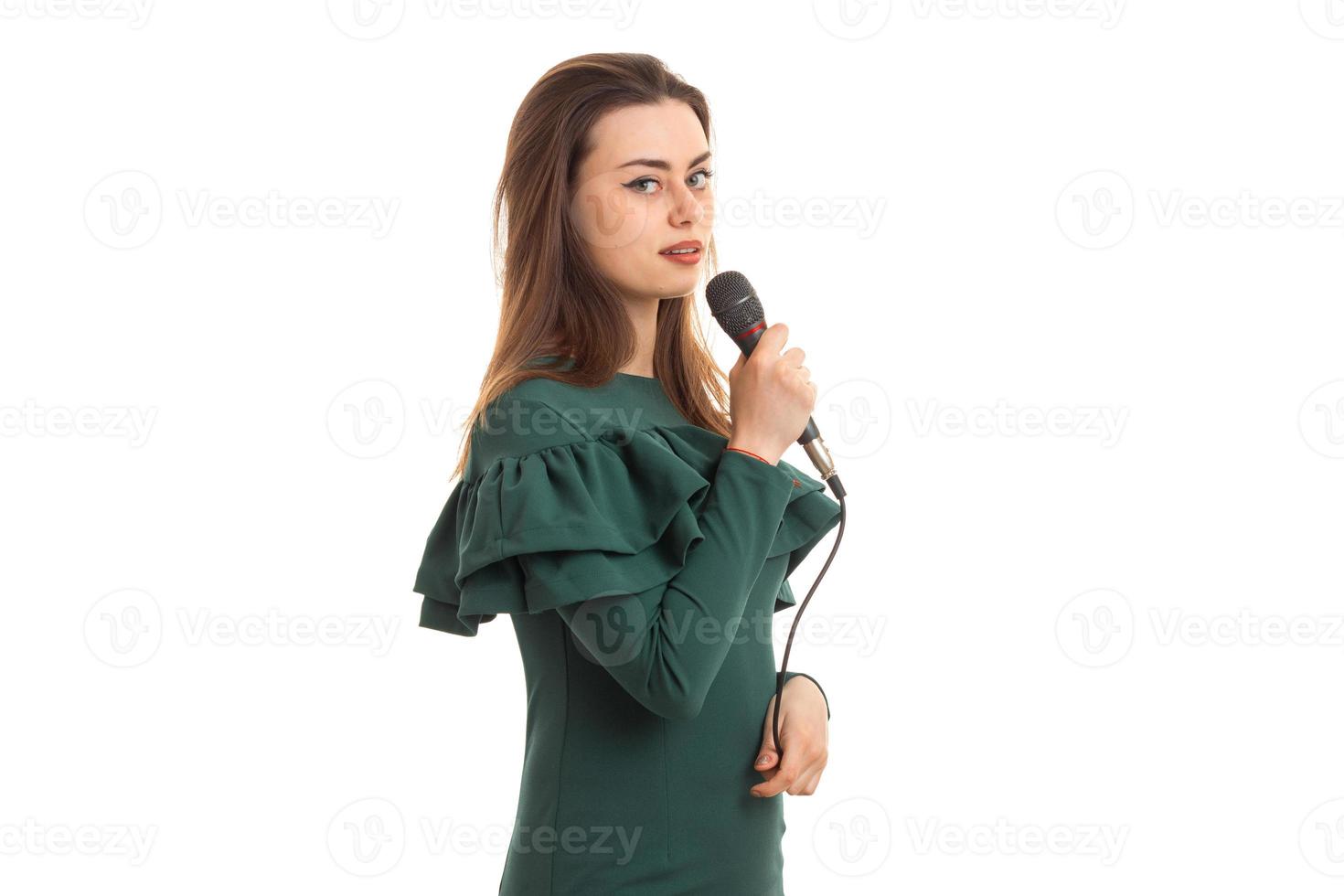 encantadora joven canta en karaoke con micrófono en mano foto