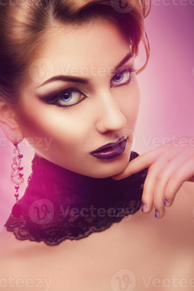 Vertical portrait of serious woman with violet make up photo