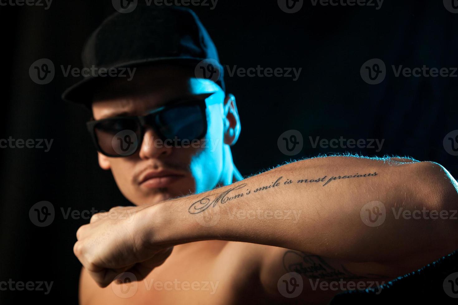 buen hombre con tatuaje en la mano en el estudio foto