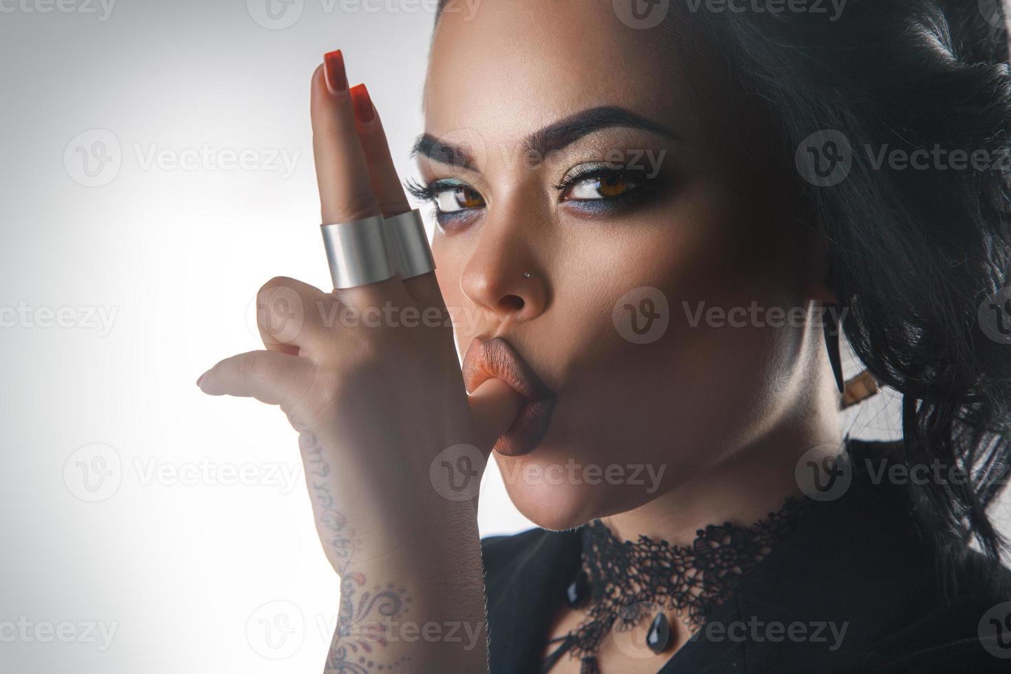 close up photo of seduce brunette with make up suck finger