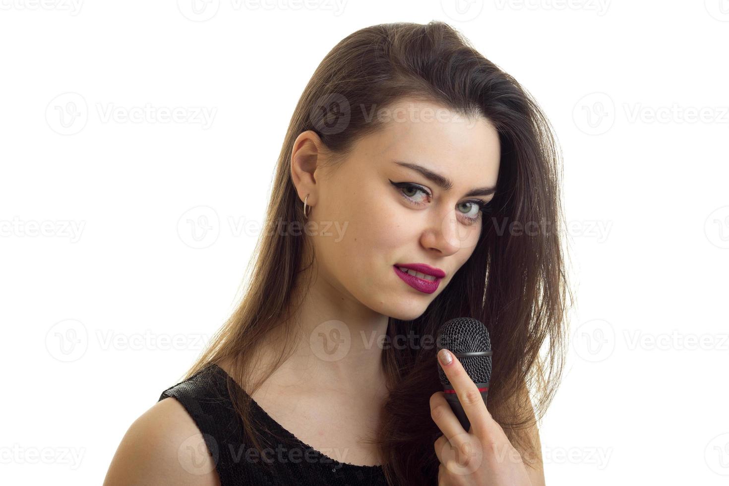 Close up portrait of beautiful young girl with make up and microphone in hands photo