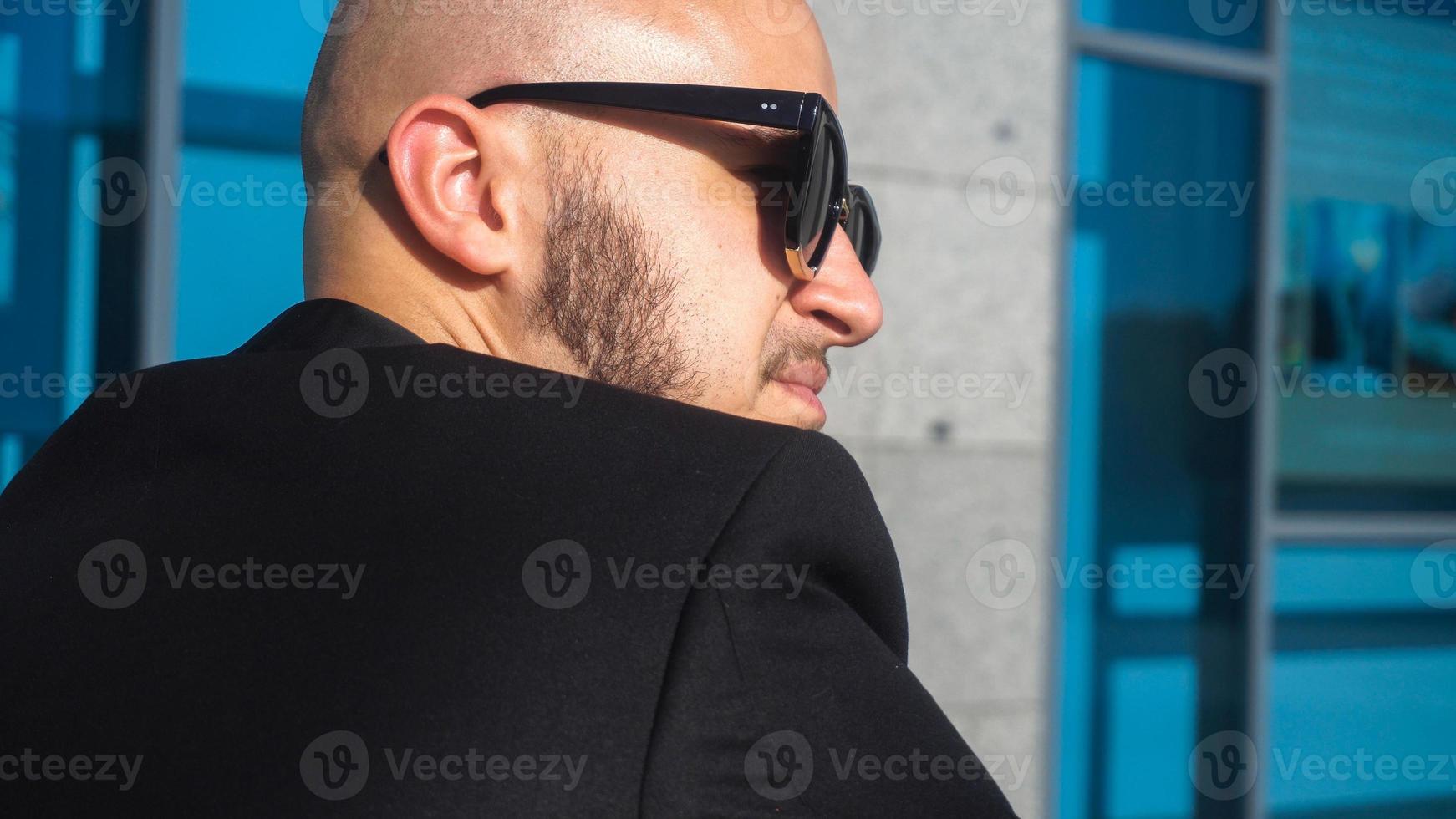 elegante joven hombre de negocios con gafas de sol negras foto