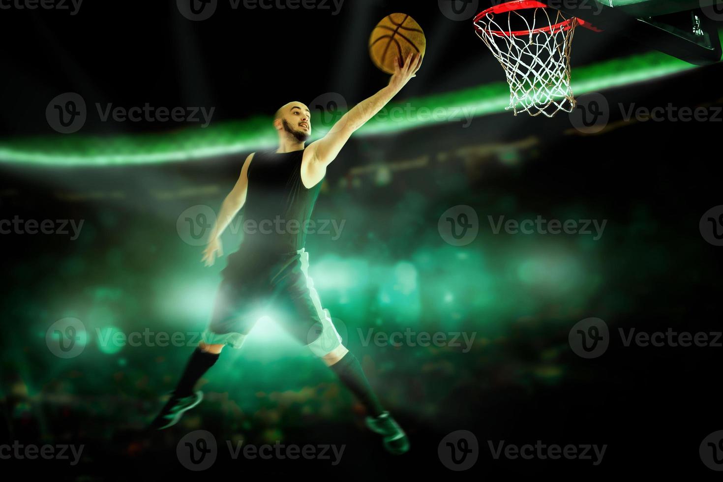 Horizontal portrait of professional basketball player makes slam dunk in the game photo